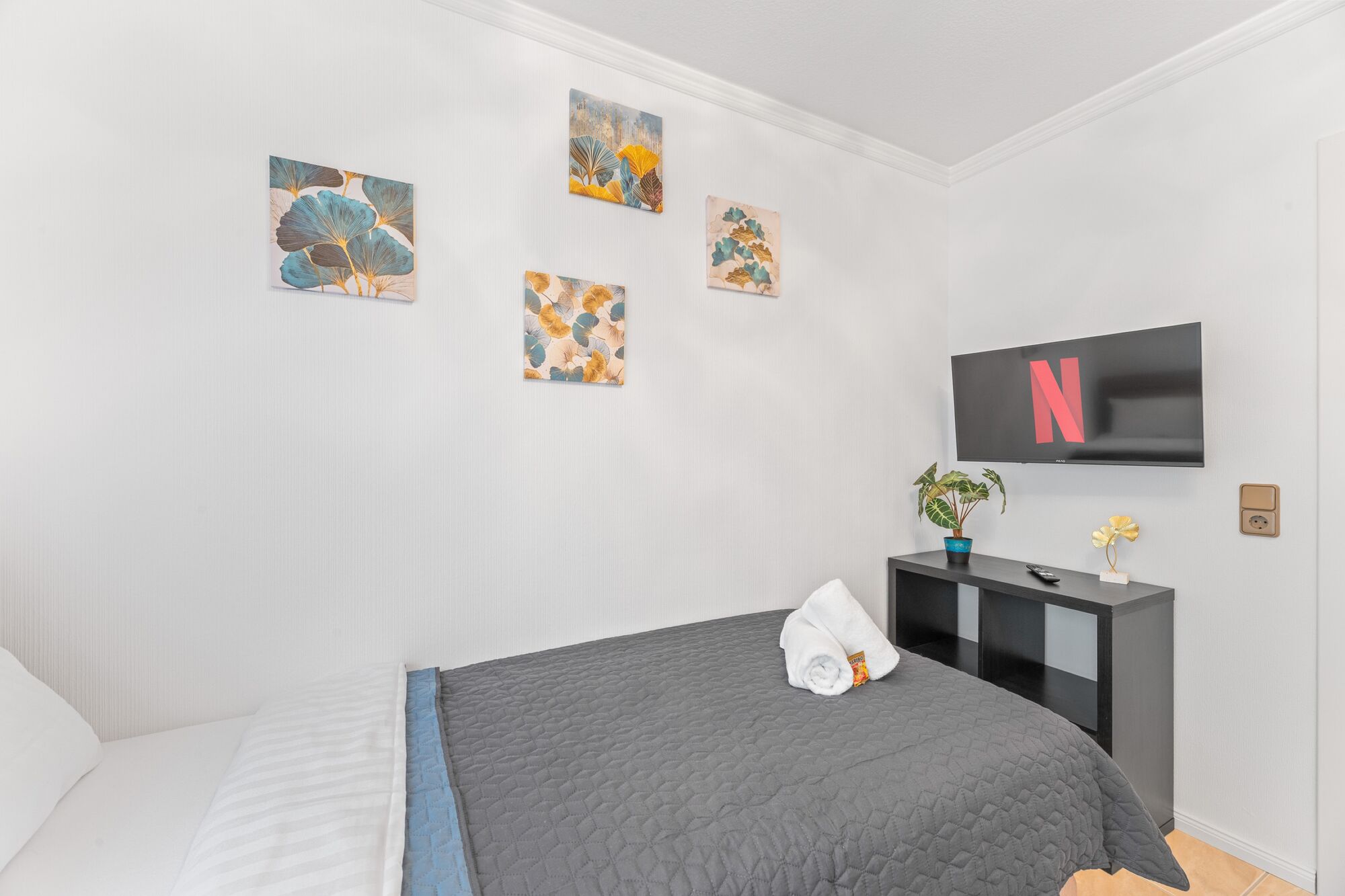 Schlafzimmer 3 mit zwei Boxspringbetten, Smart-TV und Kleiderständern.