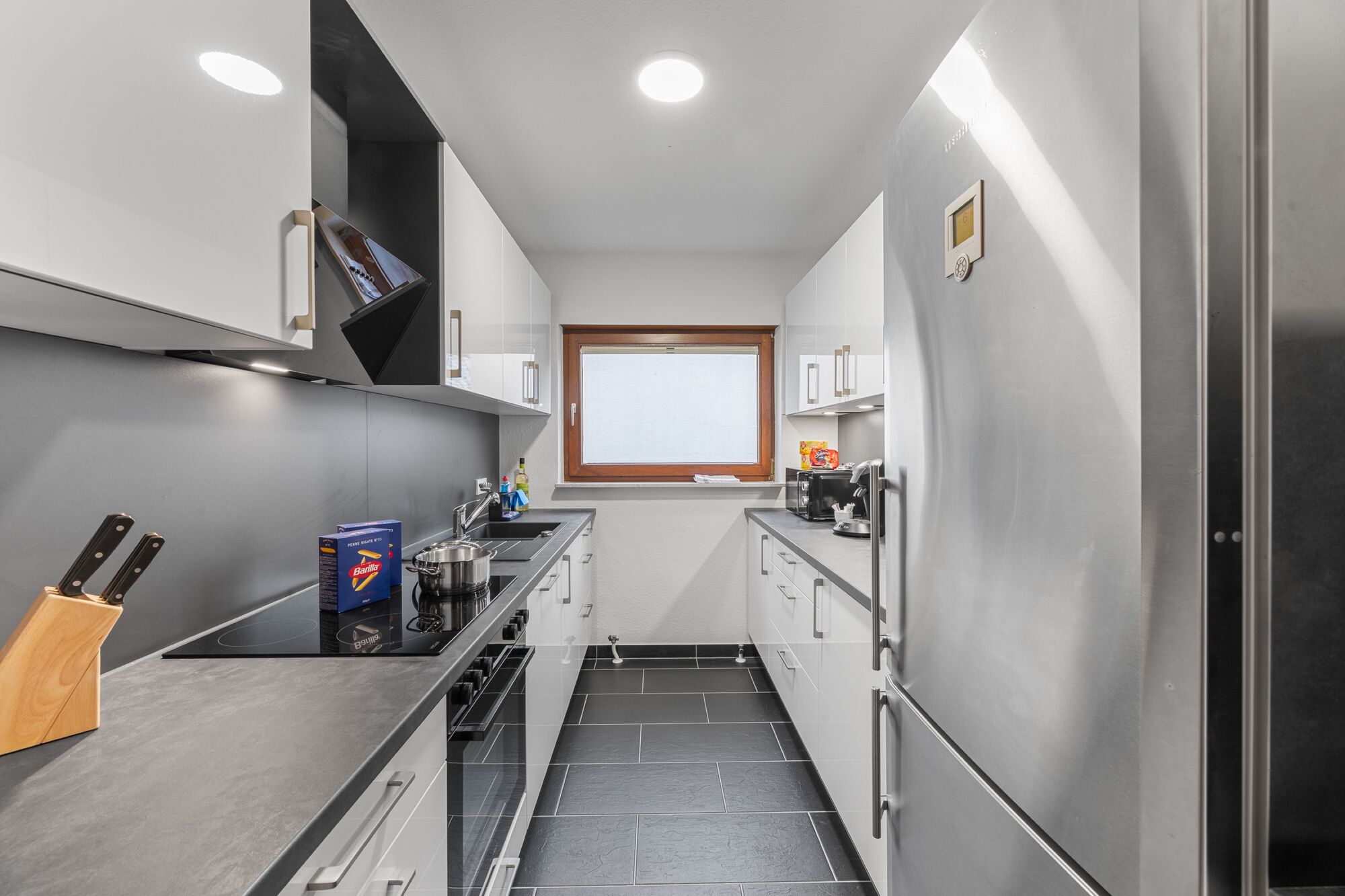 Voll ausgestattete Küche mit Herd, Backofen, sehr großem Kühlschrank und Arbeitsfläche.