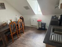 Küche mit Esstisch, Herd, Geschirr, Mikrowelle, Wasserkocher, Toaster, Besteck usw 