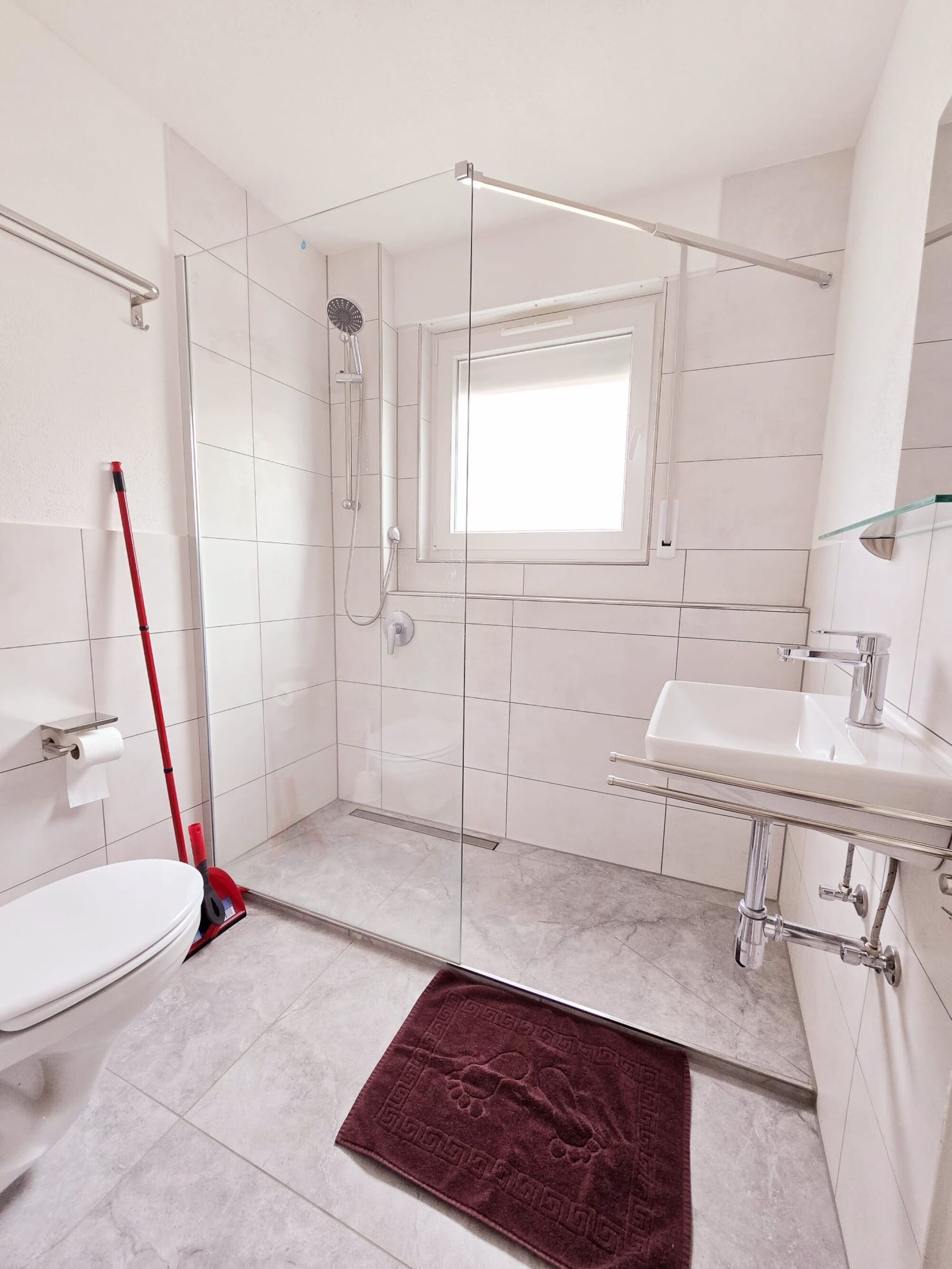 Badezimmer mit Dusche, Waschbecken und WC 