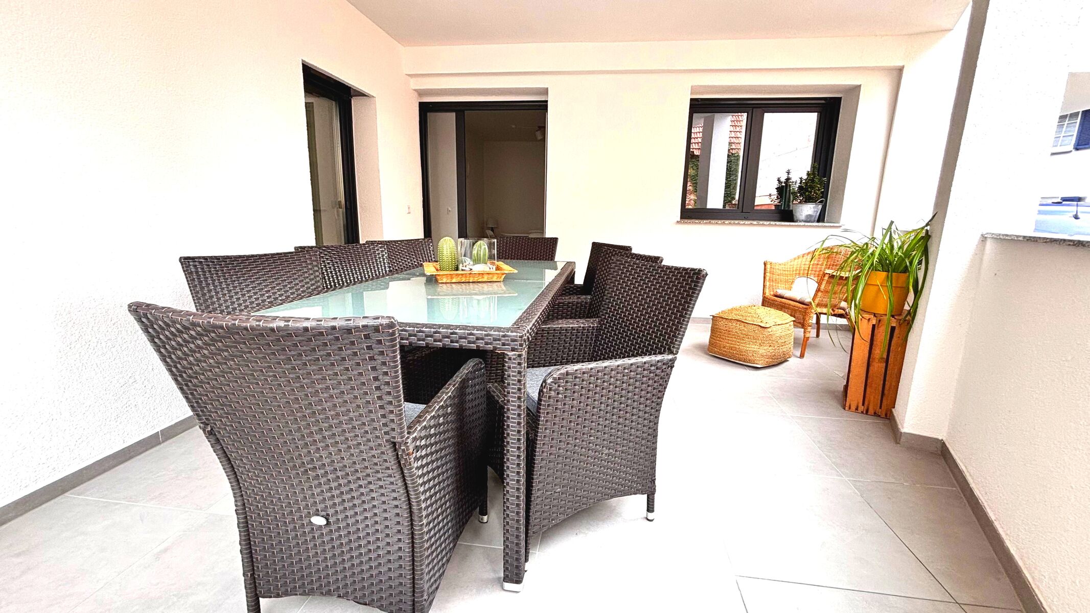 Großer, überdachter Balkon mit gemütlicher Sitzecke und Esstisch für bis zu acht Personen. Ideal zum Entspannen oder für gesellige Abende im Freien – stilvoll möbliert und dekoriert mit Pflanzen und Naturmaterialien.